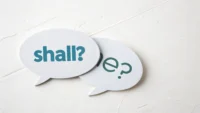 "Shall"과 "Should" 영어 표현의 차이와 사용법을 나타내는 물음표와 말풍선 아이콘.