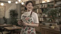 플라워 카페 직원이 영어 응대 표현 노트를 들고 미소 짓는 일러스트
